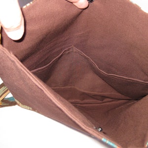 K&ouml;nnte beinhalten: Das Innere einer braunen Stofftasche mit zwei Taschen. Die Tasche hat ein buntes gemustertes Stofffutter.
