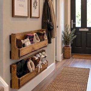 Puede incluir: Dos zapateros de madera montados en la pared, apilados y con acabado en madera oscura. Cada estante cuenta con una repisa horizontal y un riel frontal, conteniendo varios pares de zapatos, botas y zapatillas en un pasillo.