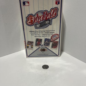 May include: A sealed 1991 edition baseball card box. The box features a baseball graphic with the text "Baseball 1991 Edition". The box also includes text about the contents, including "15 Baseball Cards Per Pack".