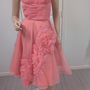 rosette strapless dress in pastel pink Structured to perfection our ANNE FLORAL STRAPLESS CORSET MINI DRESS , Sweetheart pink hues, dreamy tulle, and floral whispers that bloom with every move. A little romance, a little rebellion