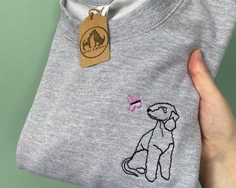 May include: Gray sweatshirt with a black embroidered image of a dog looking at a pink butterfly. The sweatshirt has a brown tag with the text "Mazie & Murphy" on it.