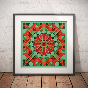May include: A framed print of a geometric design with red, green, and orange colors. The design is symmetrical and features a central circle with radiating lines.