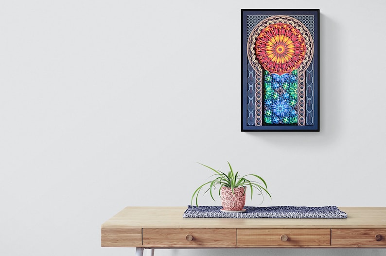 May include: A framed print of a colourful mandala design with geometric patterns in shades of red, orange, yellow, green, blue, and purple. The mandala is surrounded by a black frame.
