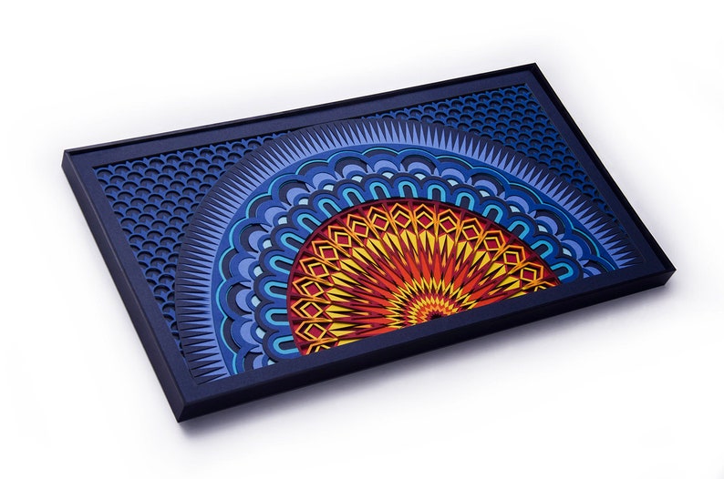 Op de afbeelding: Een rechthoekig wandkunstwerk met een gelaagd, meerdimensionaal mandala-ontwerp. Het kunstwerk toont een levendig halve-cirkelpatroon in tinten geel, oranje en rood, tegen een diepblauwe achtergrond met een honingraatstructuur.