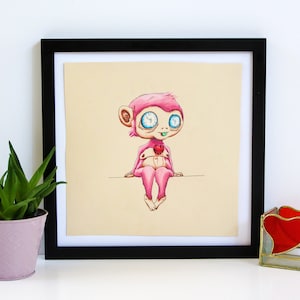 May include: A framed illustration of a pink cartoon monkey with blue eyes and a red heart in its hand. The monkey is sitting on a beige background.