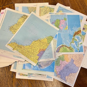 May include: A collection of vintage maps, featuring detailed geographical information. The maps display various regions with a focus on landforms, bodies of water, and political boundaries. The color palette includes blues, yellows, greens, and purples.