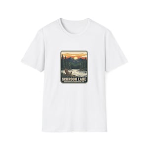 May include: White t-shirt with a rectangular graphic depicting a lake scene with mountains, trees, and a sunset. The text "SCHROON LAKE" and "ADIRONDACK MOUNTAINS, NY" are printed below the image.
