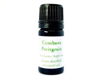 May include: A small, dark brown glass bottle with a black cap. The bottle is labeled "Combava Petitgrain Citrus hystrix / Kaffir Lime steam distilled essential oil".