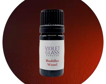 May include: A small, black glass bottle with a white label that reads "VIOLET GLASS FOREVER Buddha Wood".