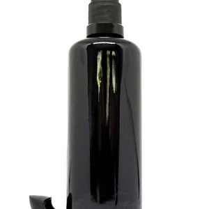 May include: A black glass bottle with a black pump dispenser. The bottle is empty and has a shiny finish.