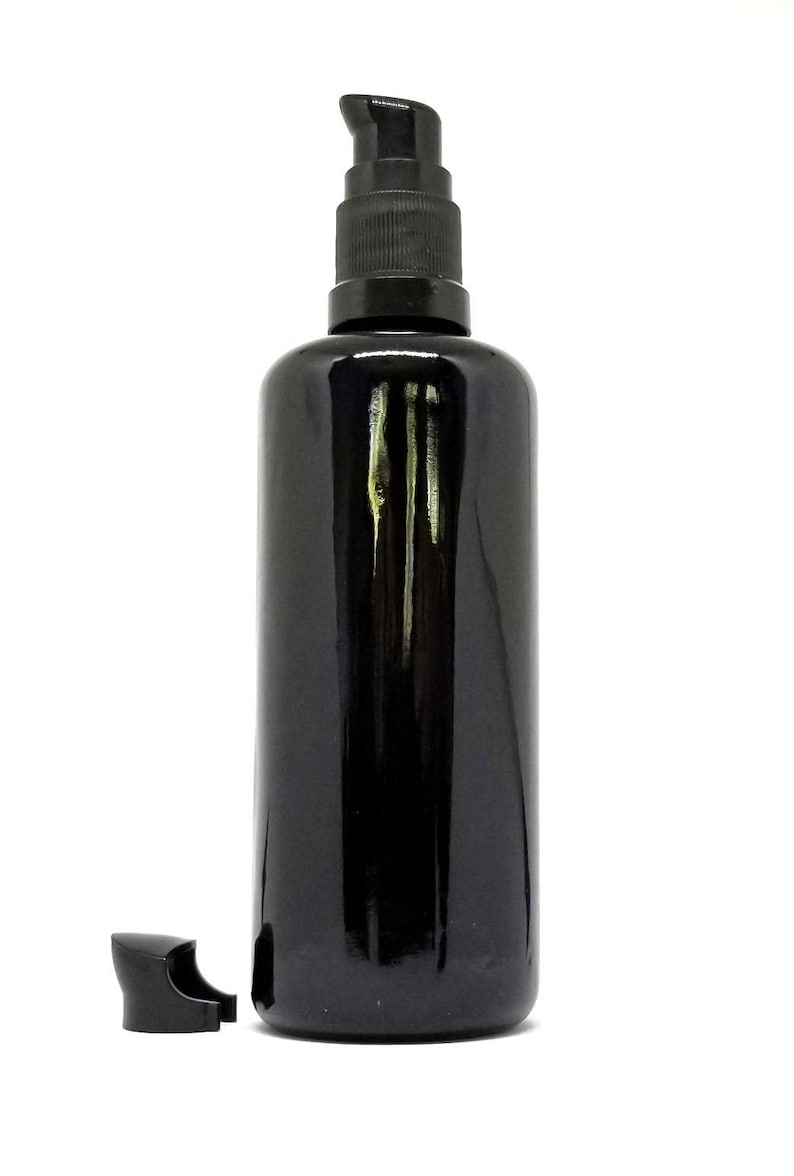 May include: A black glass bottle with a black pump dispenser. The bottle is empty and has a shiny finish.