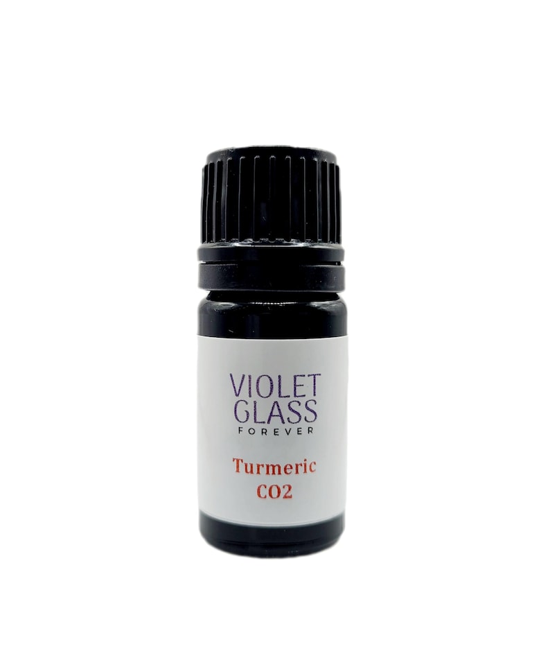 May include: A small, dark glass bottle with a black cap. The label reads "VIOLET GLASS FOREVER" and "Turmeric CO2".