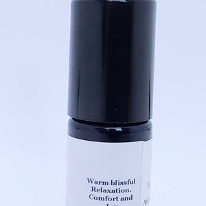 May include: A black roller bottle with a white label that reads "Warm blissful Relaxation. Comfort and Joy".