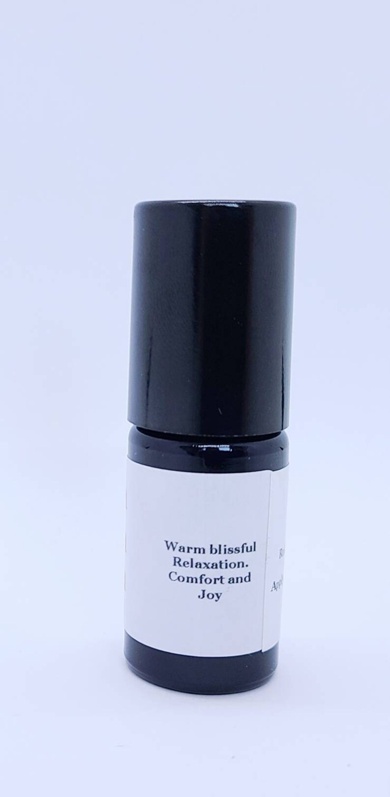 May include: A black roller bottle with a white label that reads "Warm blissful Relaxation. Comfort and Joy".