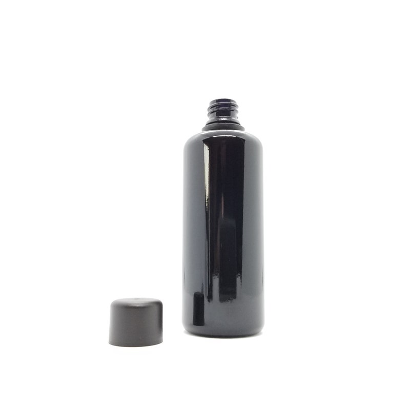 May include: A black glass bottle with a black cap. The bottle is empty and has a smooth, shiny surface.