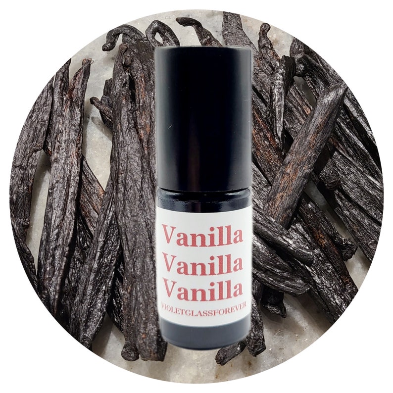 May include: A small black roller bottle with a white label that says "Vanilla Vanilla Vanilla" and "VIOLETGLASSFOREVER". The bottle is sitting on a background of dried vanilla beans.