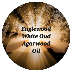 Pode incluir: Um rótulo redondo com um fundo de pôr do sol e o texto "Eaglewood White Oud Agarwood Oil".
