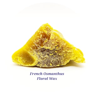May include: A close-up of a yellow block of French Osmanthus Floral Wax. The wax is textured and has a slightly grainy appearance.