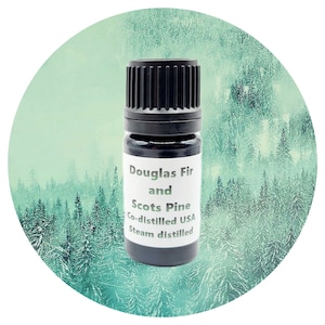 May include: A small, dark brown glass bottle with a black cap. The label reads "Douglas Fir and Scots Pine Co-distilled USA Steam distilled". The bottle is set against a background of a green and white forest.