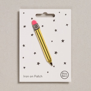 May include: Iron-on patch featuring a yellow pencil with a pink eraser. The patch is on a white card with black stars and the text "Iron on Patch" and "Petra Boase".