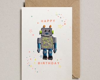 Puede incluir: Una tarjeta blanca con una ilustración de robot colorida y el texto "HAPPY BIRTHDAY" en rosa. El fondo está lleno de pequeñas estrellas de colores.