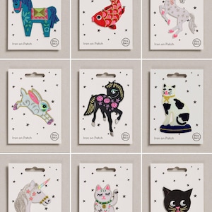 May include: A collection of nine embroidered iron-on patches on white backing cards with star patterns. Designs include a blue horse, red fish, white unicorn, jumping rabbit, black horse, sitting cat, unicorn head, white lucky cat, and black cat face.