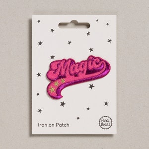 May include: Pink iron-on patch with the word "Magic" in a retro font with gold glitter stars. The patch is on a white card with the words "Iron on Patch" and a small circle with the words "Petra Boase".