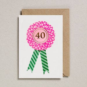 May include: A pink and white rosette with a gold number 40 in the center. The rosette has green and white striped ribbons.
