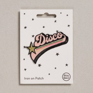 May include: Iron-on patch with a pink and black design that says "Disco" with a gold star. The patch is on a white card with black stars and the text "Iron on Patch" and a logo that says "Petra Boase".