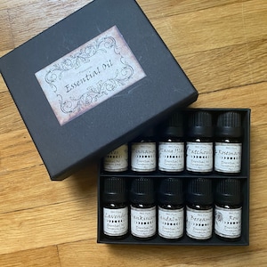 May include: A black box with a label that says "Premium Essential Oil" and contains 10 small glass bottles of essential oils. The bottles are labeled with the names of the oils, including Lavender, Frankincense, Sandalwood, Bergamot, and Rose.