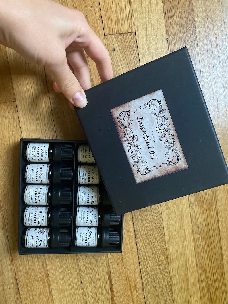May include: A black box with a label that says "Premium Essential Oil" and contains 12 small glass bottles with labels listing different essential oils.