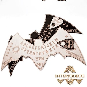 May include: Two black and white bat-shaped Ouija boards with a planchette. The boards feature the alphabet, numbers, "yes", "no", "hello", and "goodbye".