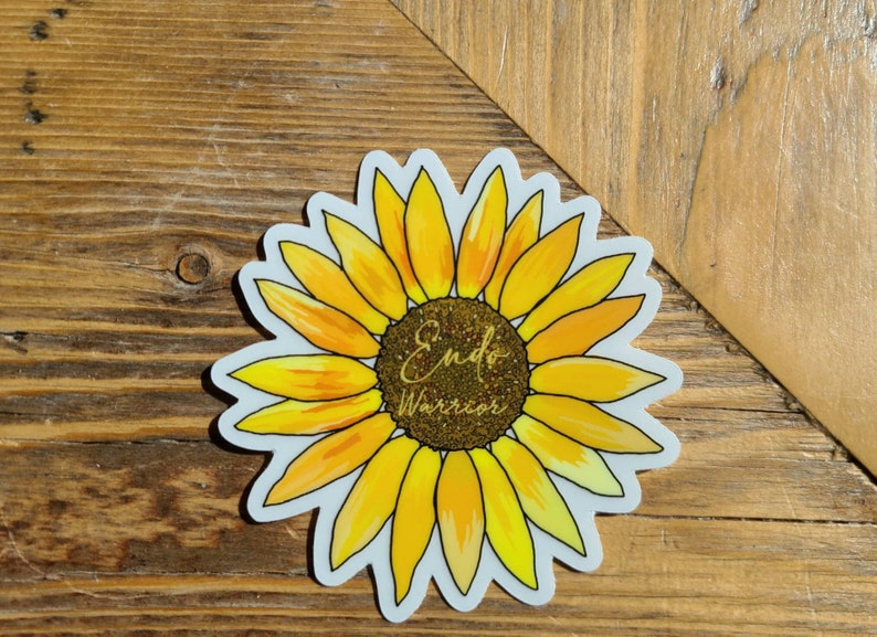 May include: A yellow sunflower sticker with the text "Endo Warrior" in gold glitter lettering.