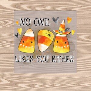 May include: A Halloween-themed card with three candy corn characters wearing witch hats and holding a spider. The card reads "No one likes you either."
