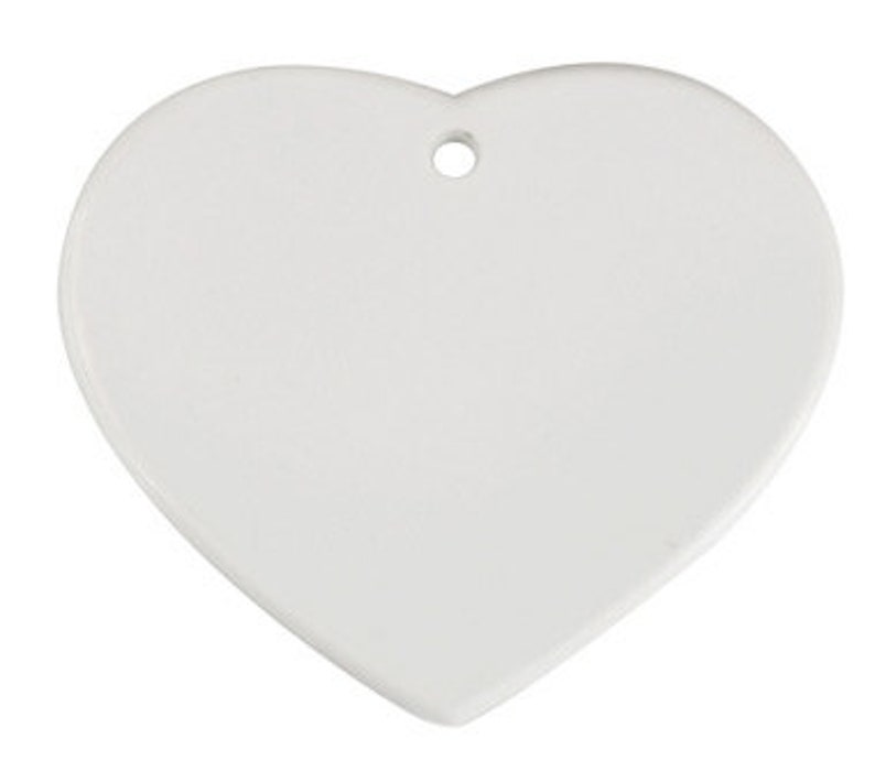 May include: White ceramic heart-shaped ornament with a hole at the top for hanging.