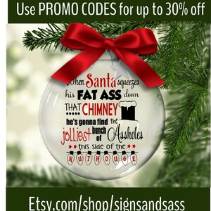 May include: A clear glass Christmas ornament with a red bow and text. The text reads "When Santa squeezes his FAT ASS down THAT CHIMNEY...he's gonna find the jolliest bunch of Assholes...this side of the NUTHOUSE."
