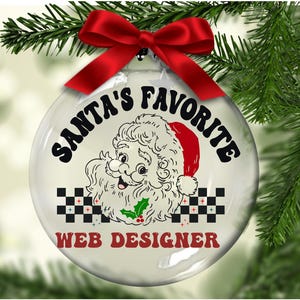 May include: A clear glass Christmas ornament with a red bow and green pine needles in the background. The ornament features a cartoon Santa Claus design with the text "SANTA'S FAVORITE WEB DESIGNER" in black and red.