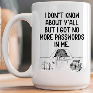 May include: White ceramic mug with the text "I DON'T KNOW ABOUT Y'ALL BUT I GOT NO MORE PASSWORDS IN ME." A black and white illustration shows a person with their head on a desk, a laptop, books, and a mouse.