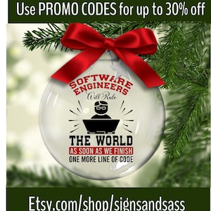 May include: A clear glass Christmas ornament with the text "SOFTWARE ENGINEERS Will Rule THE WORLD AS SOON AS WE FINISH ONE MORE LINE OF CODE." The ornament is decorated with a red bow and set against a backdrop of pine needles.