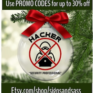 May include: A clear glass Christmas ornament with a red ribbon and pine branches. The ornament has the word "HACKER" in black, crossed out with a red line, and a graphic of a person at a laptop. The text "SECURITY PROFESSIONAL" is below.