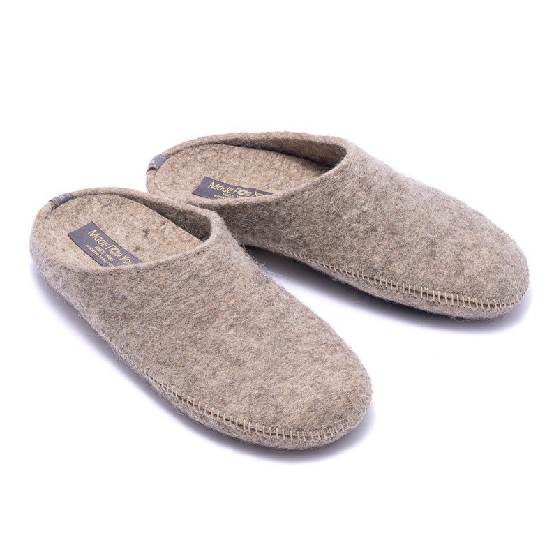 100% wool slippers with rubber soles in various widths and fits. Home shoes are comfortable due to arch support and natural fibers. Women's slippers are dark beige and grey melange color in natural fibers that prevent feet from sweat and odors