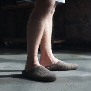 May include: A pair of gray wool slippers with a closed toe and a simple design.