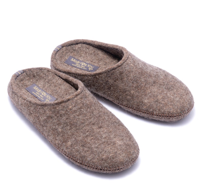 100% wool slippers with rubber soles in various widths and fits. Home shoes are comfortable due to arch support and natural fibers. Women's slippers are brown and dark beige melange color in natural fibers that prevent feet from sweat and odors