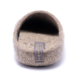 May include: A pair of gray felt slippers with a brown label that reads "Made for You" and "US Navy Size 7".