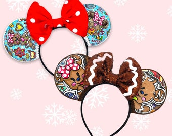 May include: A pair of gingerbread-themed Minnie Mouse ears with a brown bow and a blue bow. The ears are decorated with gingerbread men and women, candy canes, and snowflakes.