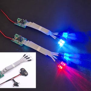 May include: Two LED light sets with circuit boards, ribbon cables, and red and black wires. One set emits blue light, the other red and blue. A smaller image shows a battery connector.