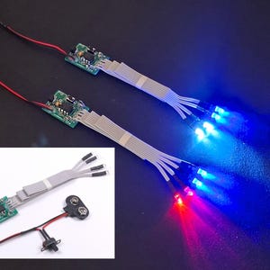 May include: Two LED light sets with red and blue lights. Each set includes a circuit board, ribbon cable, and multiple LED lights. The lights are illuminated, showcasing their vibrant colors. An inset image shows a similar set with a battery.