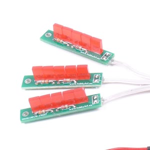 May include: Three green circuit boards with red components and white wires. Each board has a row of red rectangular pieces. The boards are arranged on a white background. The text "www.hobbykit.eu" is visible on the boards.