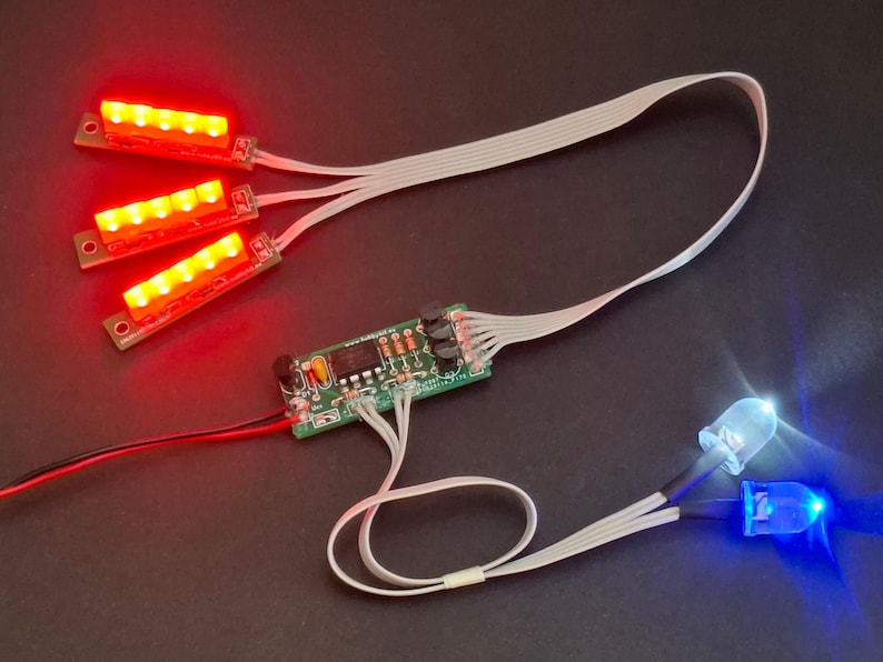 May include: Electronic circuit board with red and blue LED lights. Three red LED light strips are connected to the circuit board with white ribbon cables. Two individual LEDs, one blue and one white, are also connected.