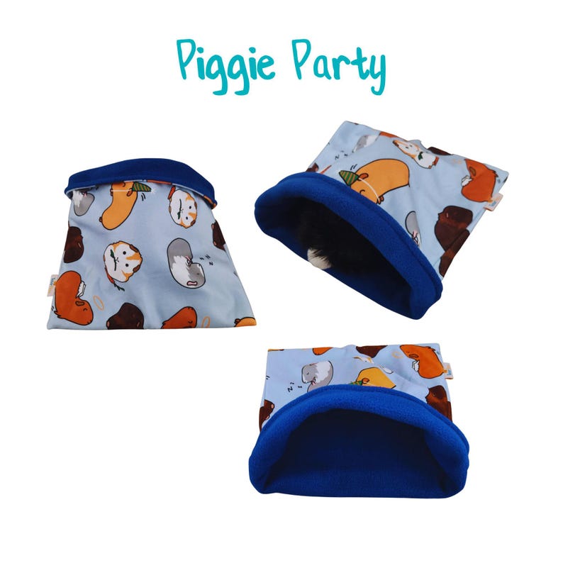 May include: Blue and white fabric guinea pig sleeping bag with a blue fleece lining. The fabric has a pattern of cartoon guinea pigs. The sleeping bag is labeled "Piggie Party".